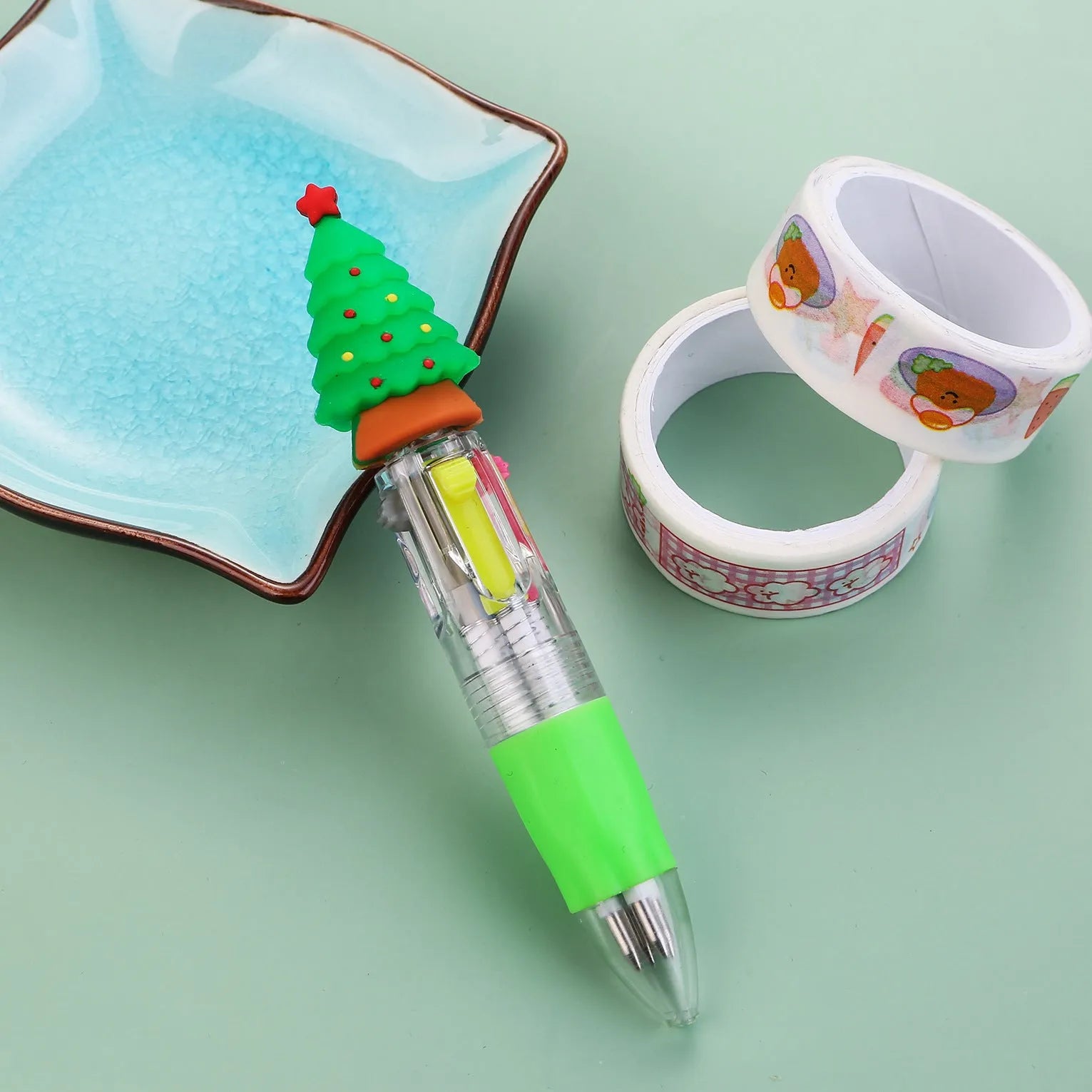 Christmas-themed ballpoint pen with press button, showing designs of snowmen, reindeer, and trees on plastic barrel.