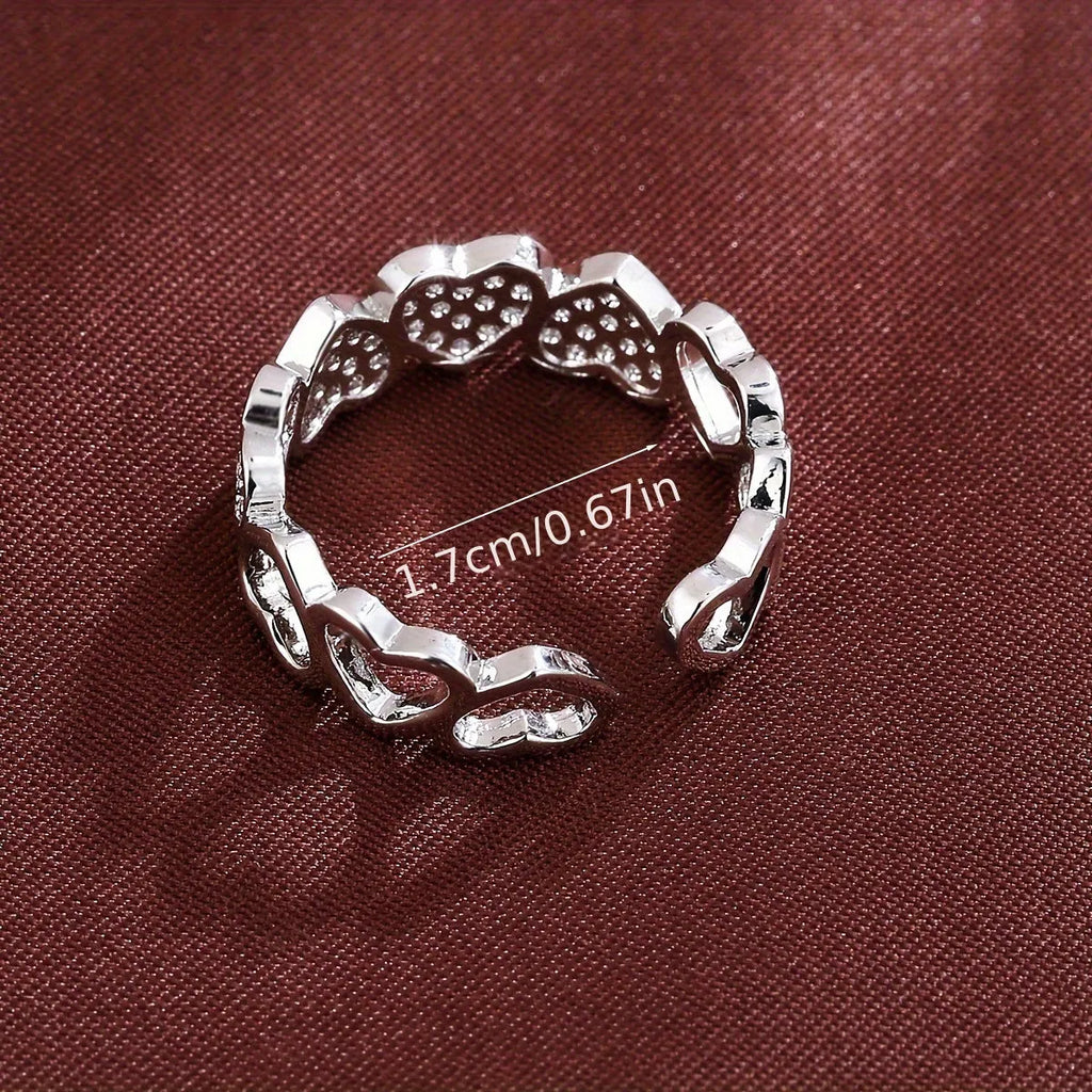 Gold copper couple ring with adjustable opening and love heart design on plain background