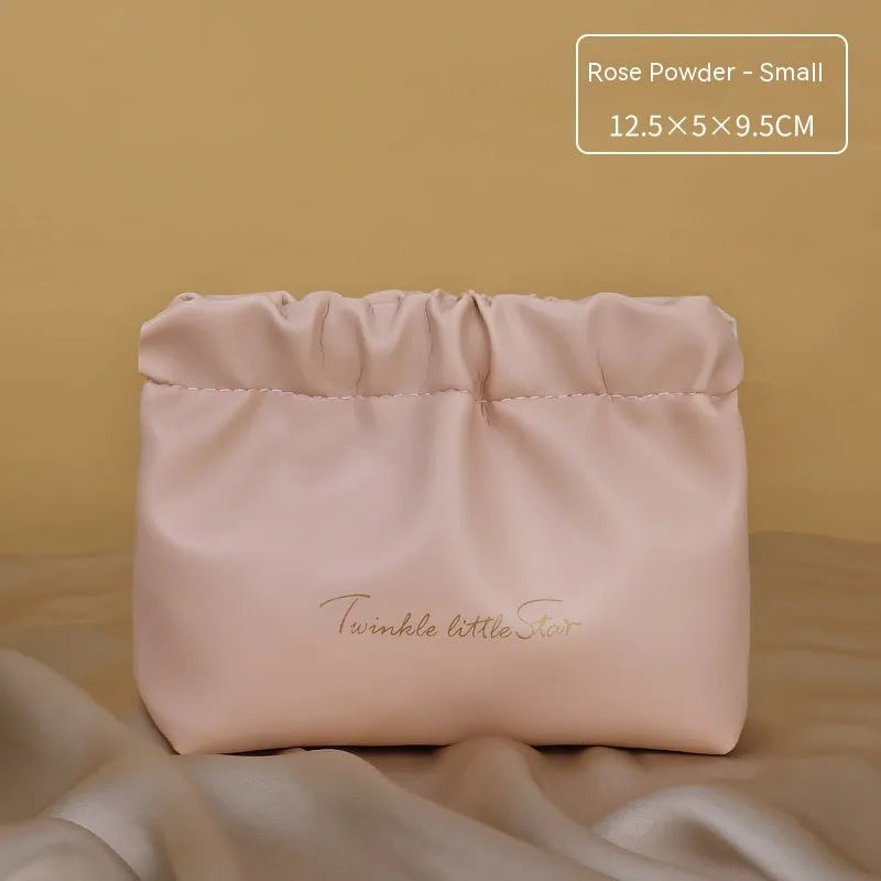 Leather travel toiletry bag in caramel mocha colour showing storage compartments and decorative letter details