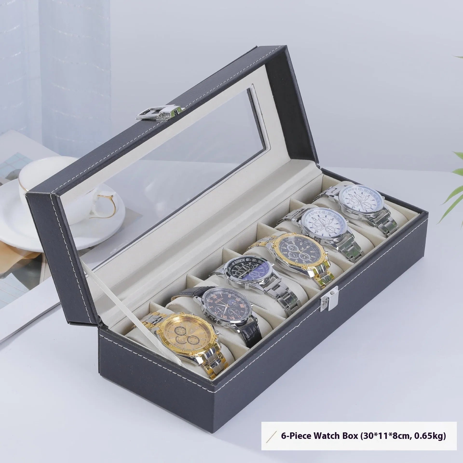 Grey leather watch storage box with clear lid showing watch compartments