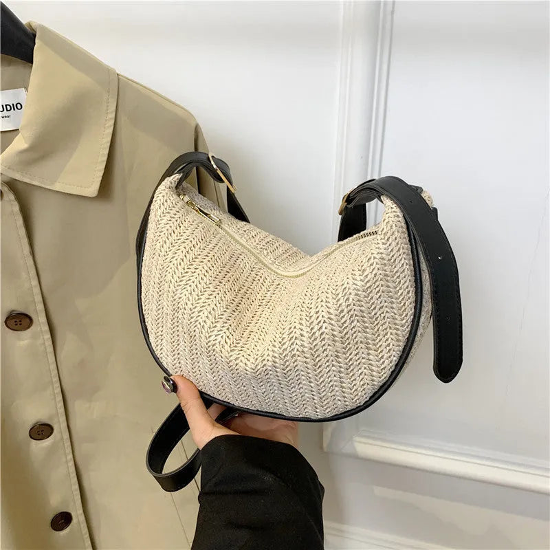 Women's straw woven crossbody bag showing knitted weaving texture and internal phone pocket