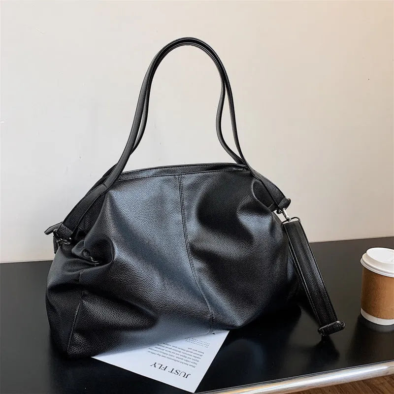 Large soft PU leather messenger bag in khaki colour with adjustable shoulder strap and top handle.