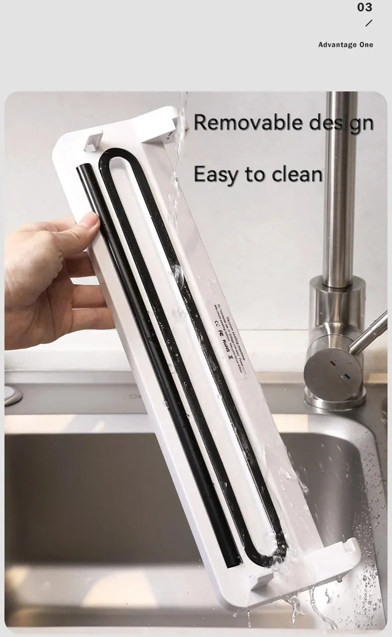 Small black automatic vacuum sealer machine on a kitchen countertop