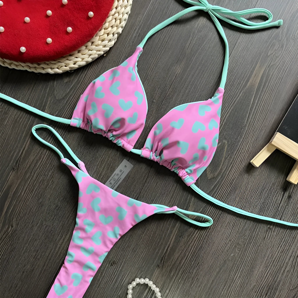 Heart print backless one-piece swimsuit with a split briefs style on a mannequin.