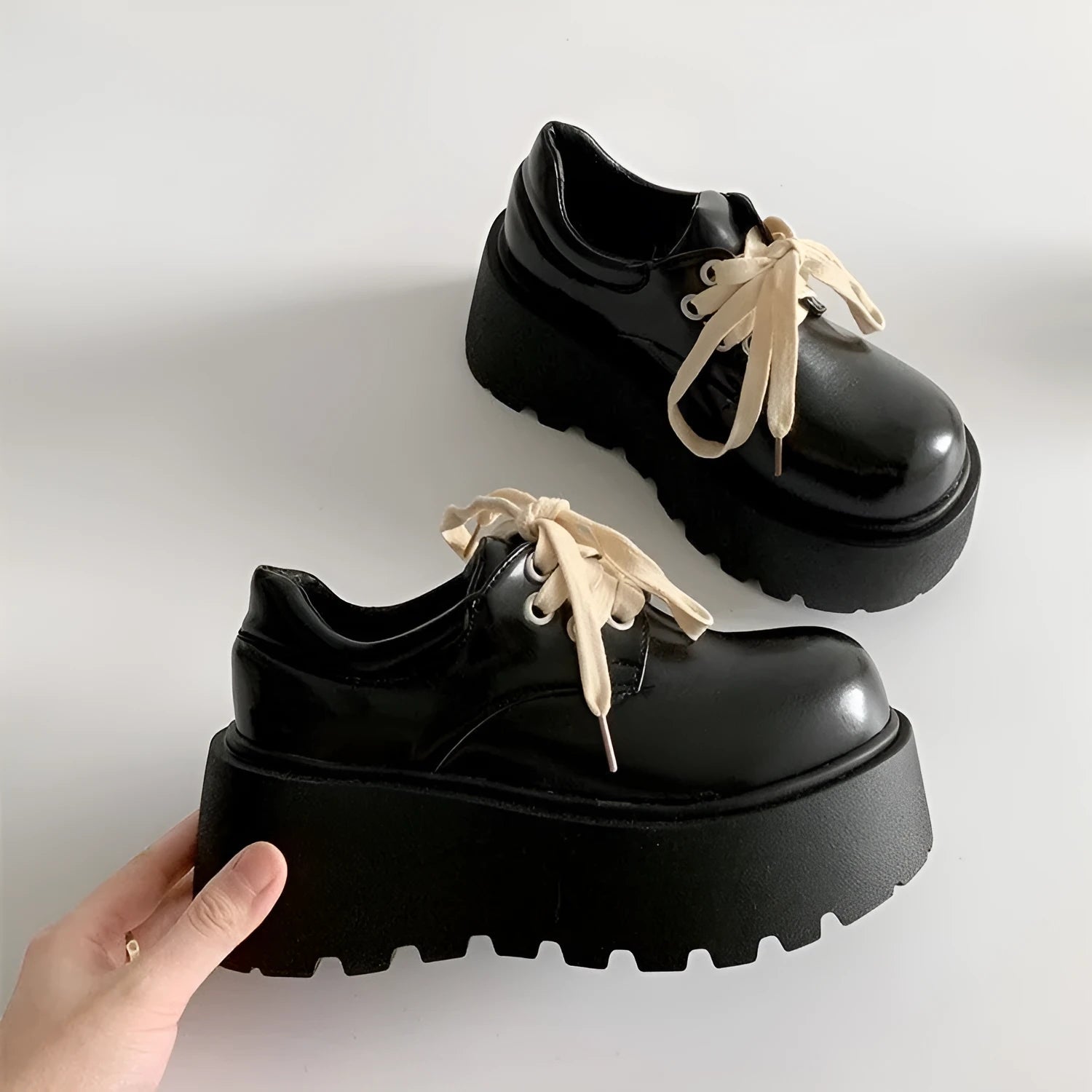 Matte black women's high-heel shoes with a thick rubber sole and lace-up buckle.