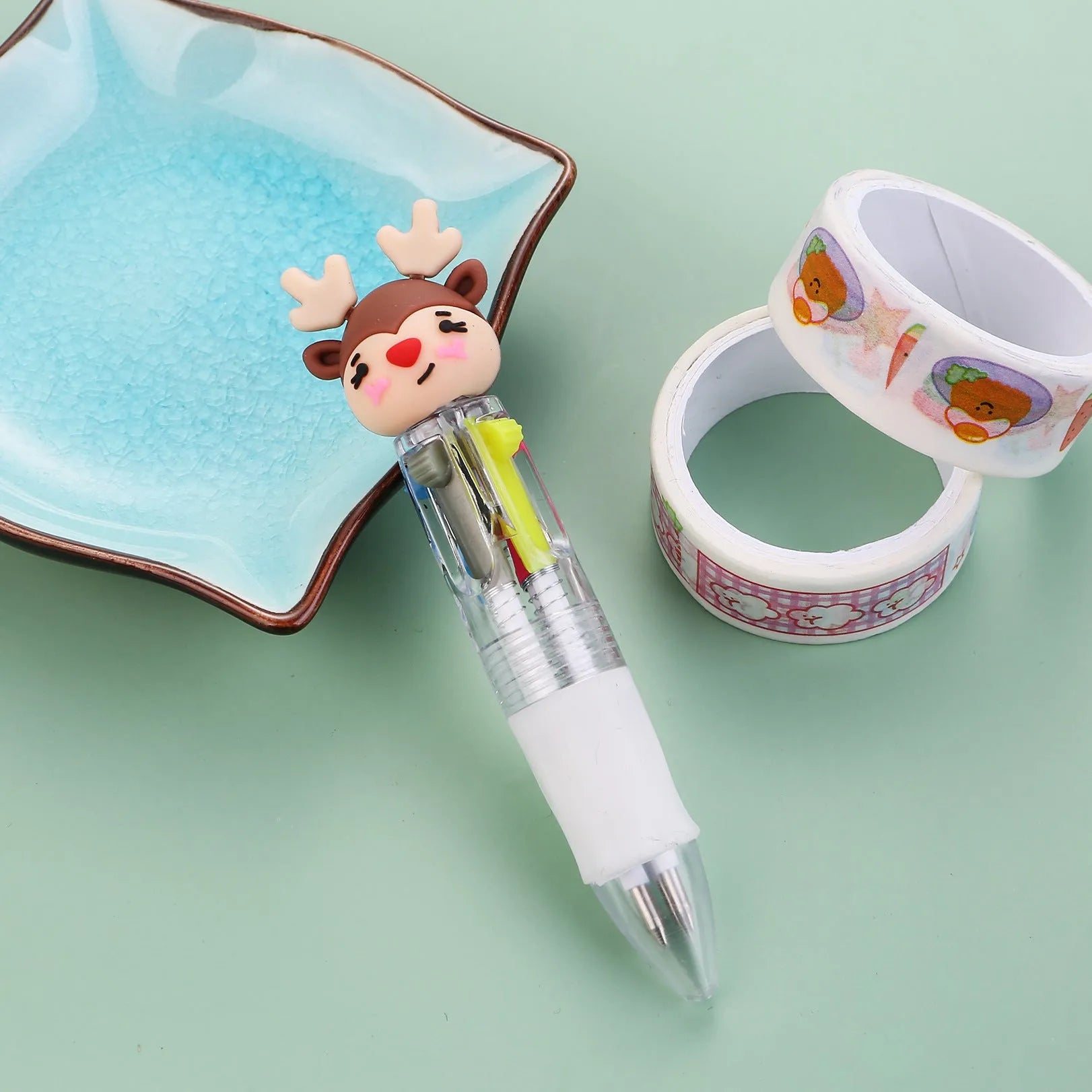 Christmas-themed ballpoint pen with press button, showing designs of snowmen, reindeer, and trees on plastic barrel.