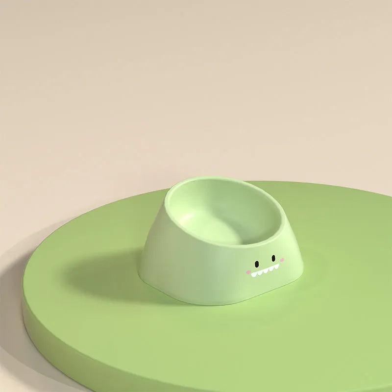 Green tilted stainless steel cat bowl at a 15-degree angle on a table.