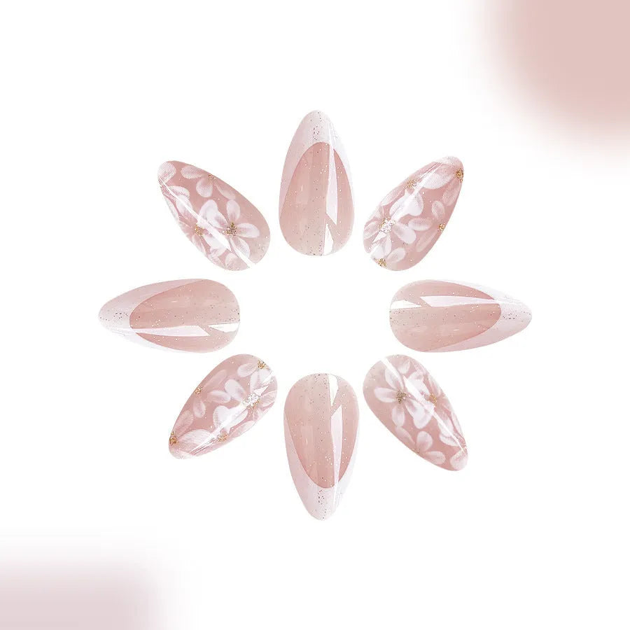 Short almond shaped removable false nails with glossy French tips and glitter flower decoration, colour C625.
