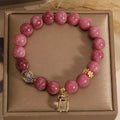 Natural stone bracelet with lotus tassel pendant and pearl details in pink lotus colour