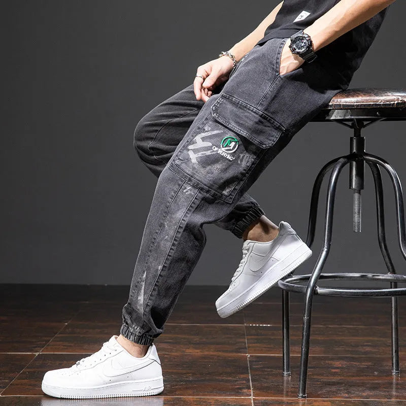 Man wearing loose fit straight leg cargo jeans in blue, showing zipper fly and cargo pocket detail.