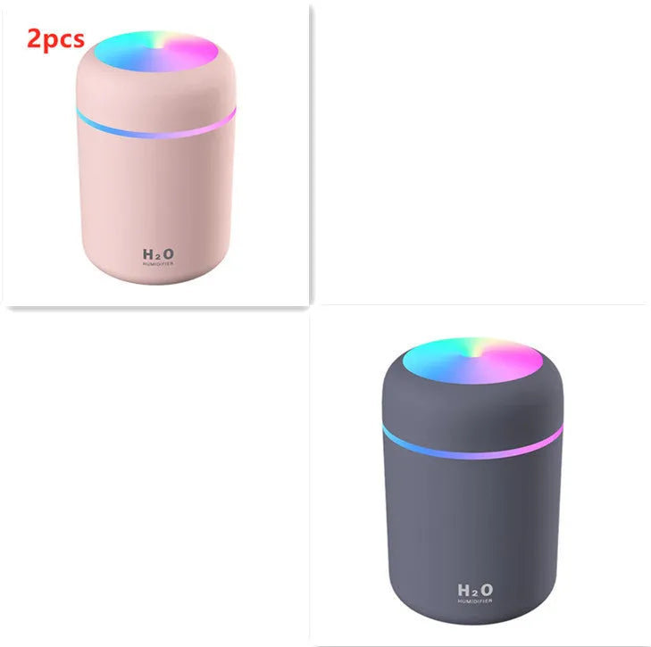 Pink USB mini humidifier with LED lights and water tank on desk