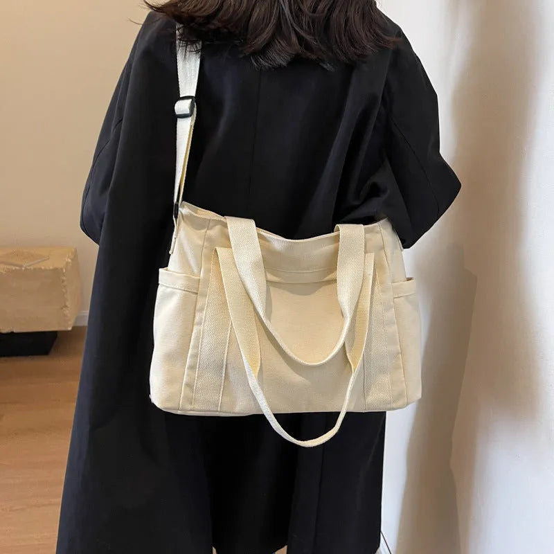 Large polyester canvas shoulder tote bag in solid colour with outer pocket and shoulder strap