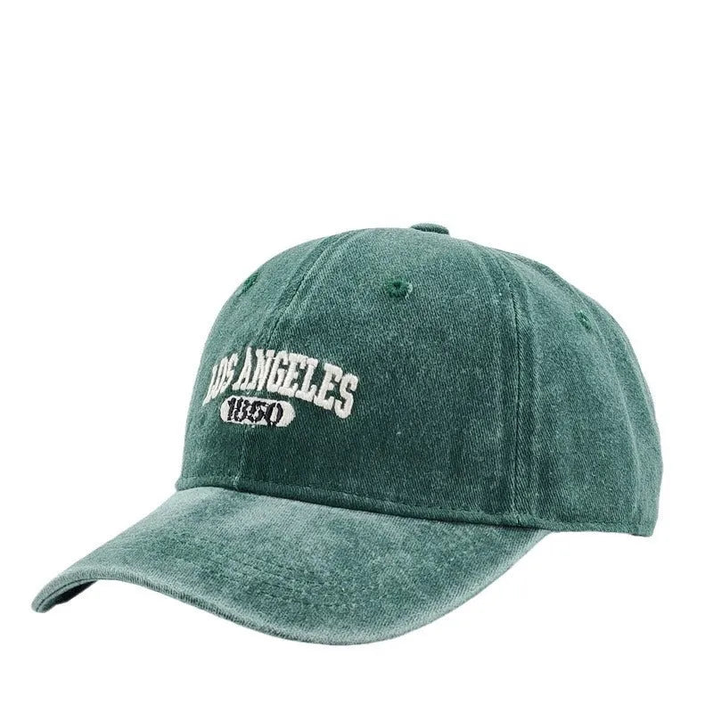 Retro washed distressed embroidered peaked cap with adjustable strap on a conical crown.