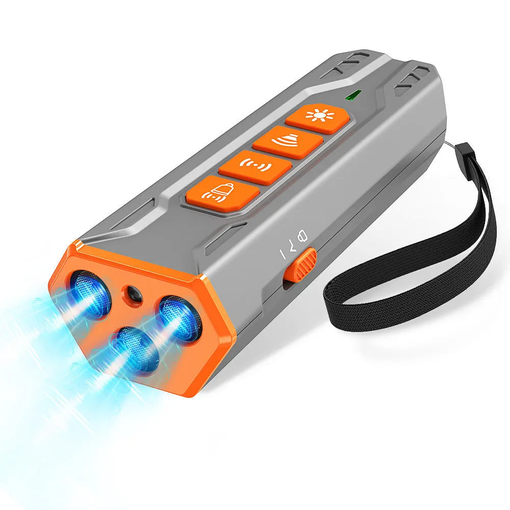 Grey and orange coloured three-head ultrasonic dog trainer with remote control on a table.