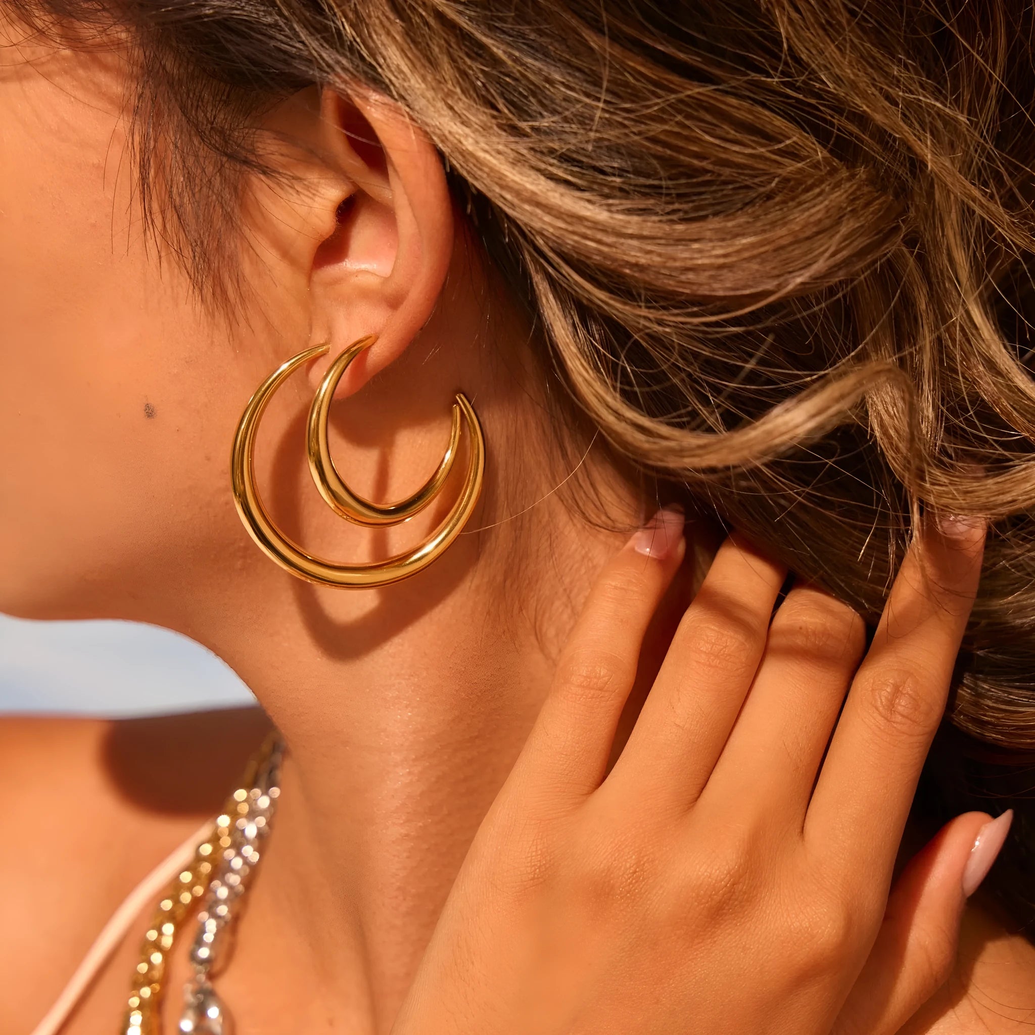 Geometric round stainless steel hoop earrings with gold plating, shown in large and small sizes.