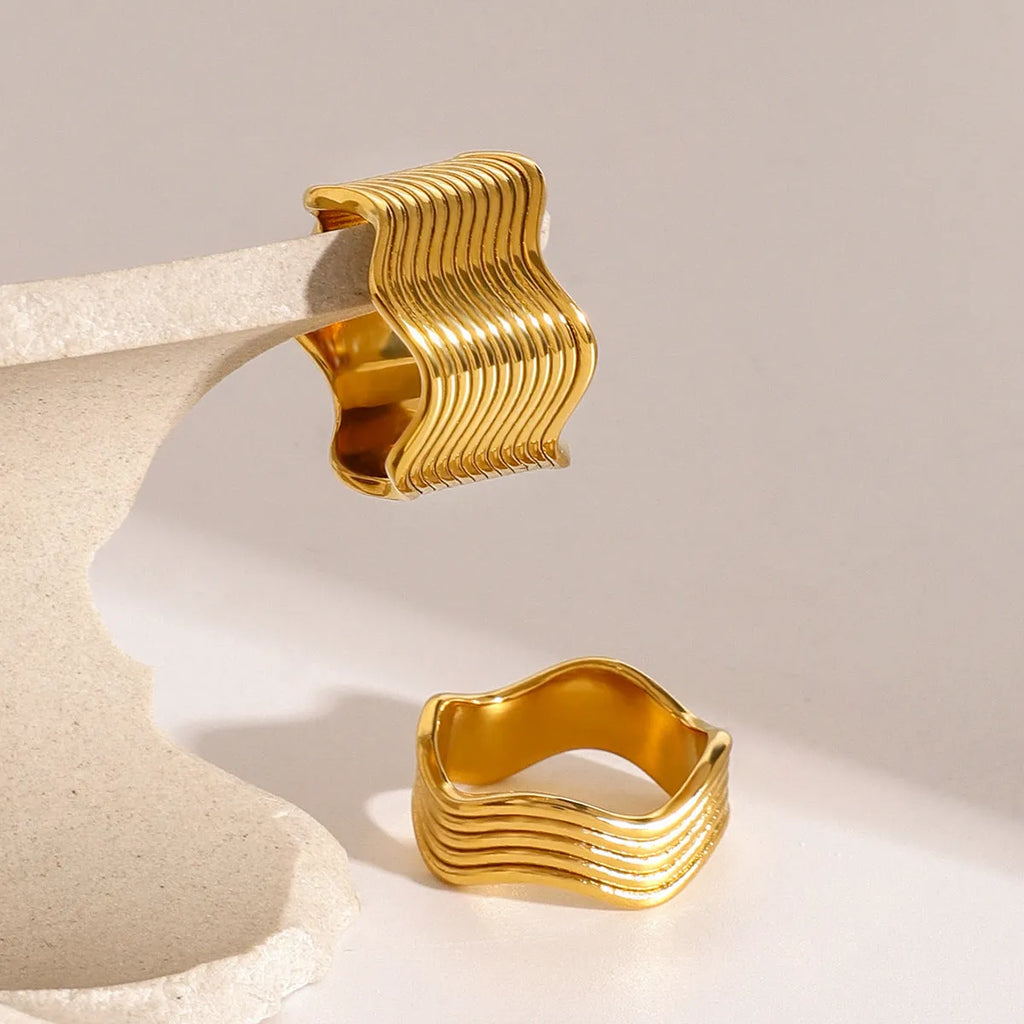 A stainless steel women's ring with a wide, geometric wave design in a Korean style.