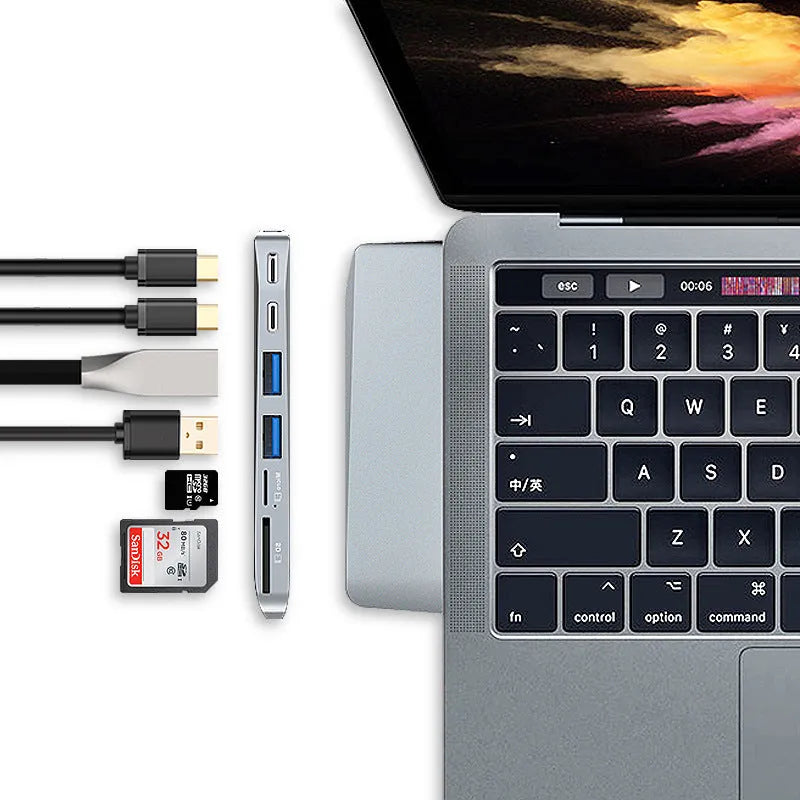 Silver USB-C multi-port hub for MacBook Pro with eight interface ports including USB, card slots, and display output