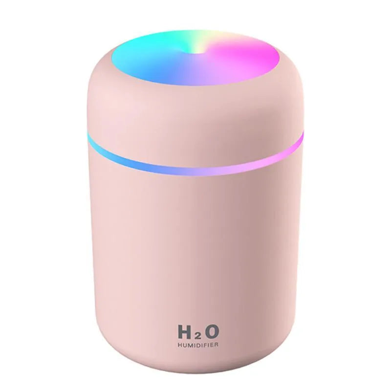 Pink USB mini humidifier with LED lights and water tank on desk