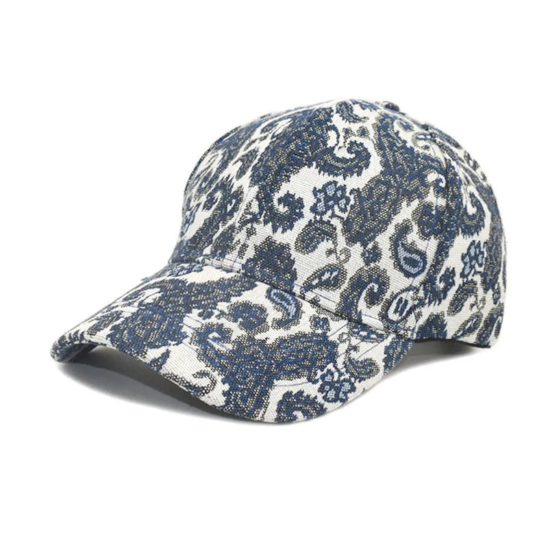 Blue polyester baseball cap with a white paisley pattern, showing the dome crown style.