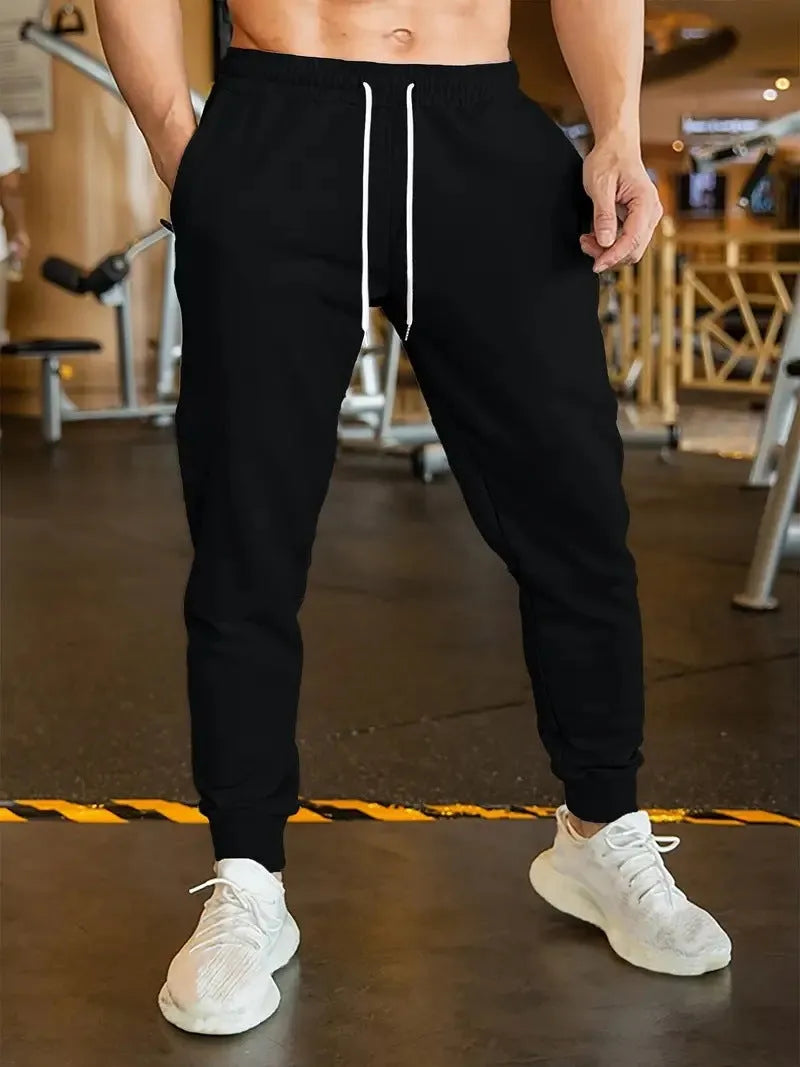 Men's loose fit linen-style trousers with a drawstring elastic waist, shown in a casual setting.