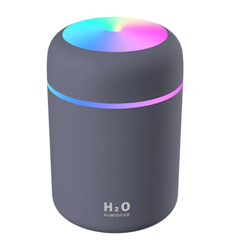 Pink USB mini humidifier with LED lights and water tank on desk