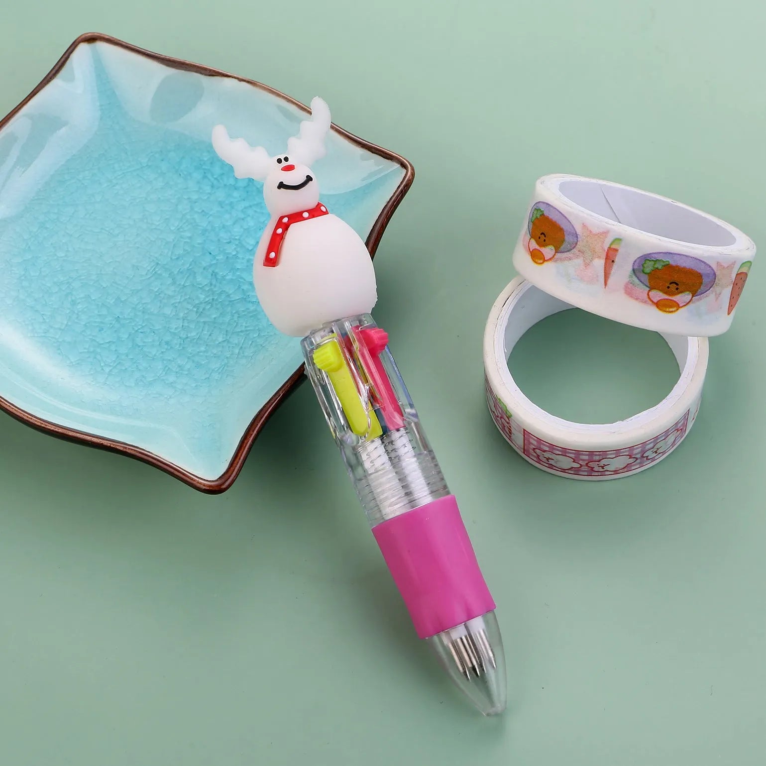 Christmas-themed ballpoint pen with press button, showing designs of snowmen, reindeer, and trees on plastic barrel.