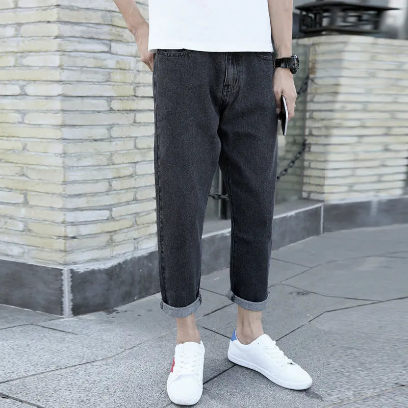 A pair of men's loose straight-leg jeans in a blue colour on a plain background.