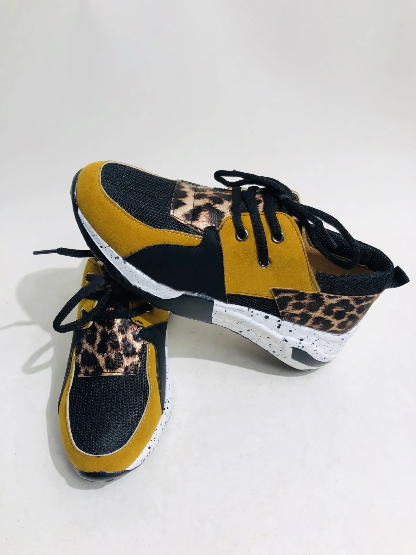 Women's black suede casual sneakers with a wedge heel and round toe on a light background.