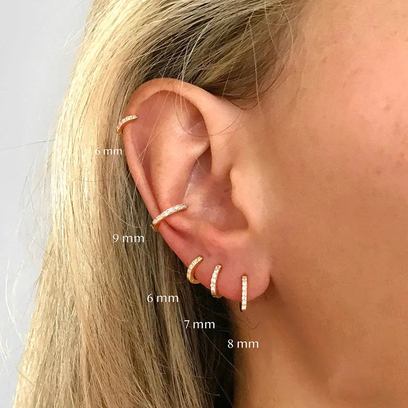 Gold, rose gold, and silver coloured geometric circle stud earrings with a perforated centre on a white background.