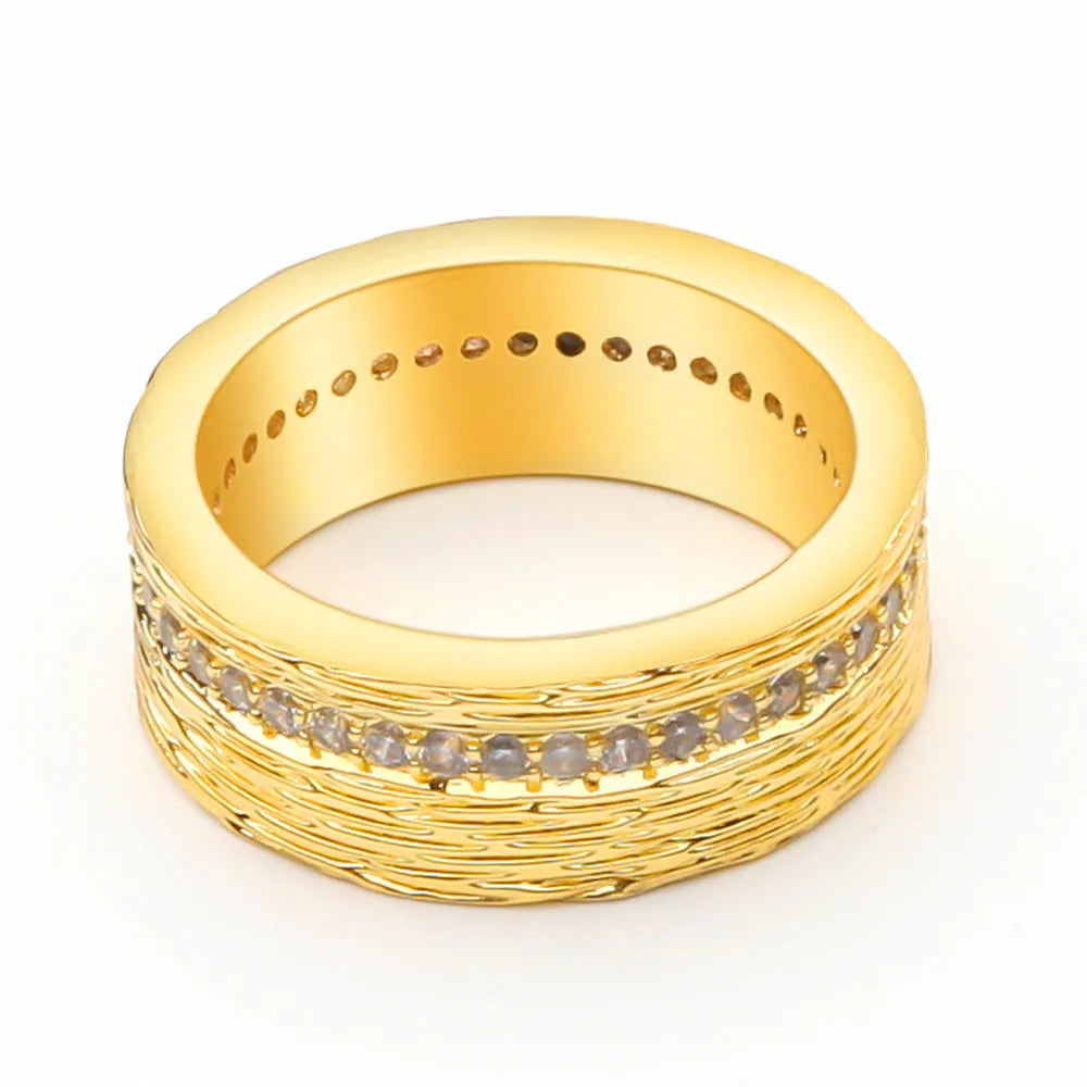 Gold coloured geometric zircon ring for women on a plain background, showing its structured shape.
