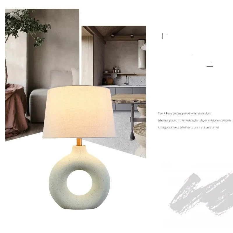 Japanese-style white ceramic table lamp with a button switch on a wooden desk.