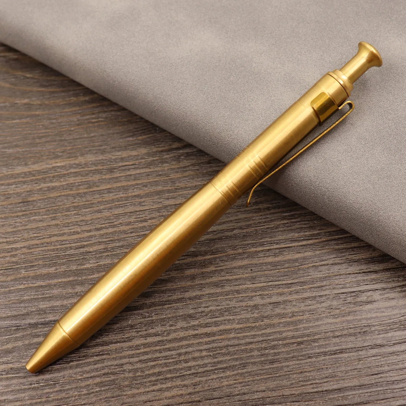 Retro brass tactical pen with press bolt-action mechanism and cylindrical metal barrel