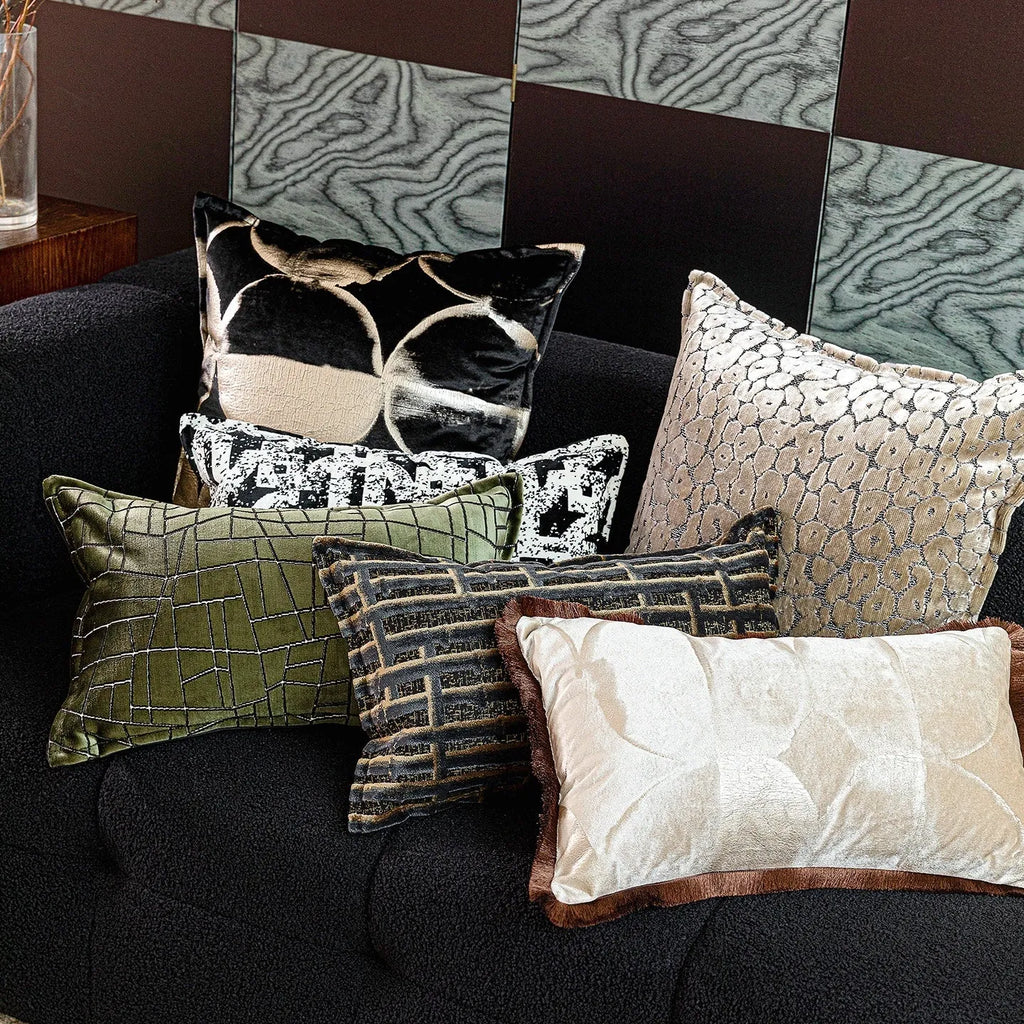 Black and gold abstract patterned flannel cushion in square and bolster sizes on a grey sofa.