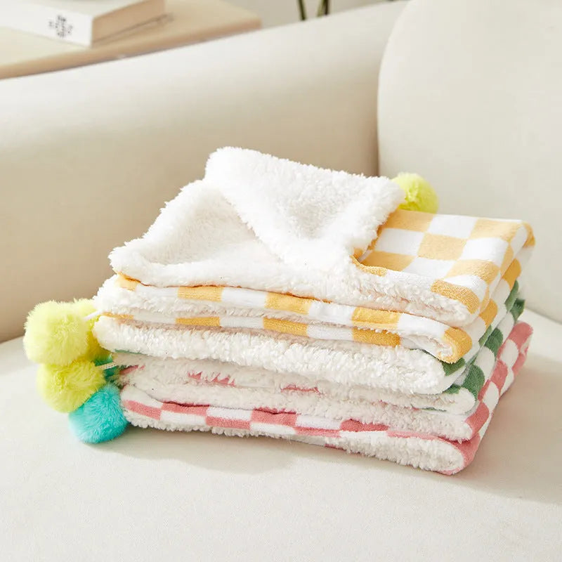 Green plaid plush pet blanket for dogs and cats on a sofa
