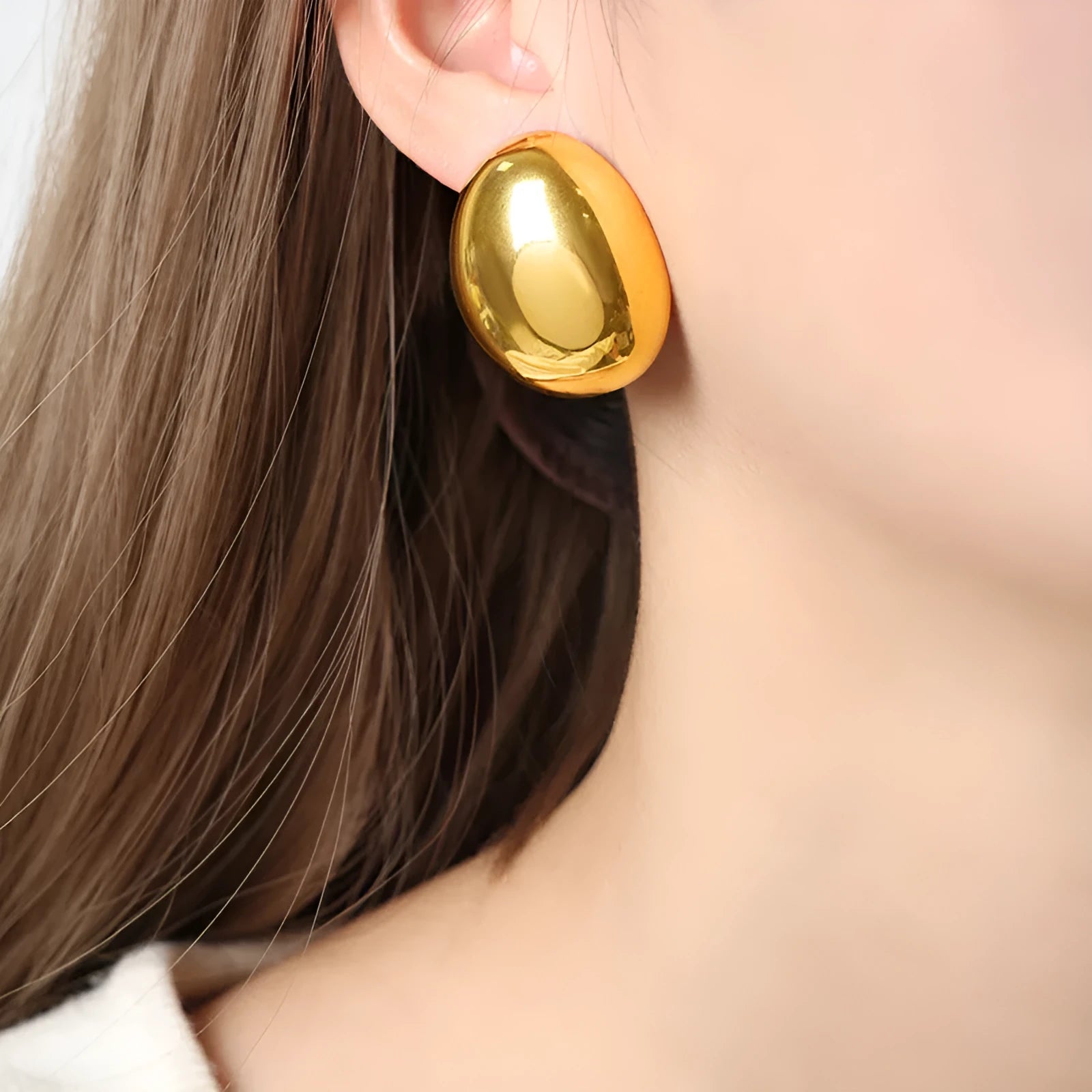 Close-up of simple geometric stainless steel stud earrings with 18K gold plated glazed finish and line design.