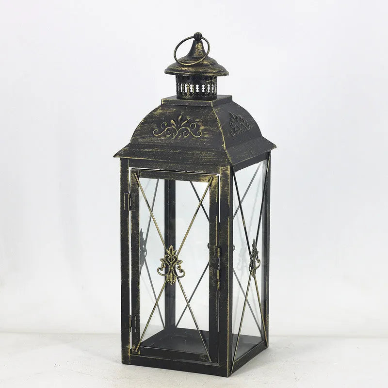 Black wrought iron floor-standing storm lantern with tempered glass panels for outdoor candle lighting