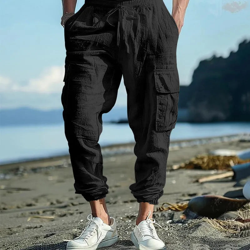 Men's solid colour linen casual trousers with ankle-tied cuffs, multiple pockets, and a drawstring waist