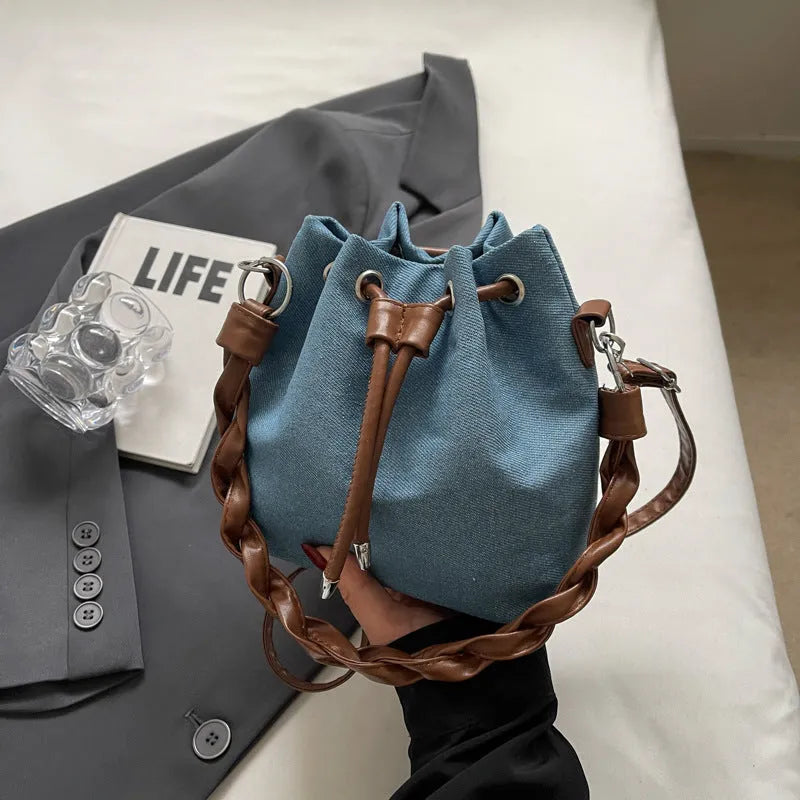Blue one-shoulder cross body bucket messenger bag with an external sandwich pocket.