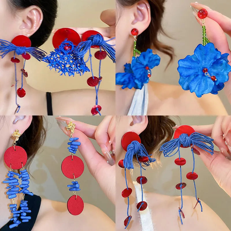 Women's geometric blue and silver fabric drop earrings with a resin flower detail.