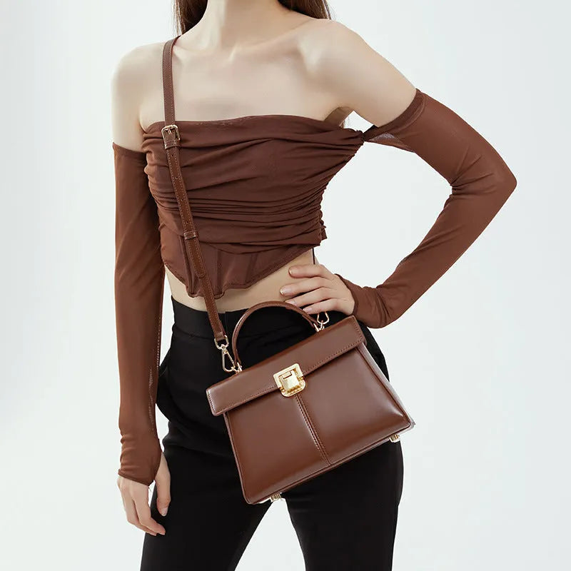 Black genuine vachette leather women's shoulder bag with clasp closure, showing square shape and adjustable strap.