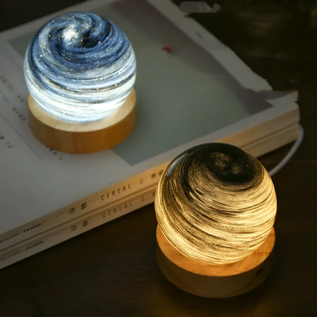 Planets themed USB night light with modern design and three-colour dimming on bedside table.