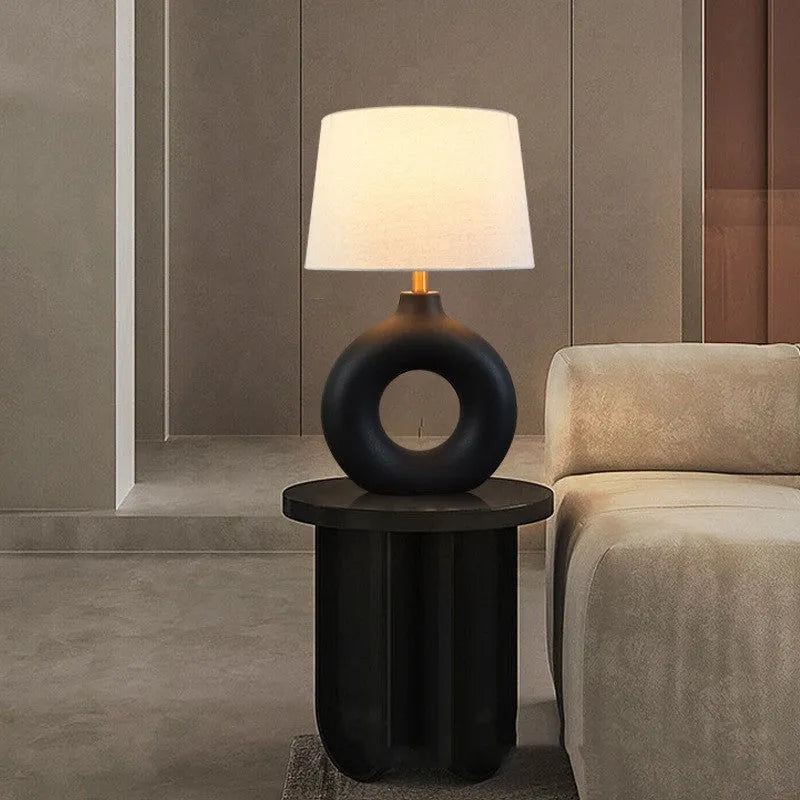Japanese-style white ceramic table lamp with a button switch on a wooden desk.