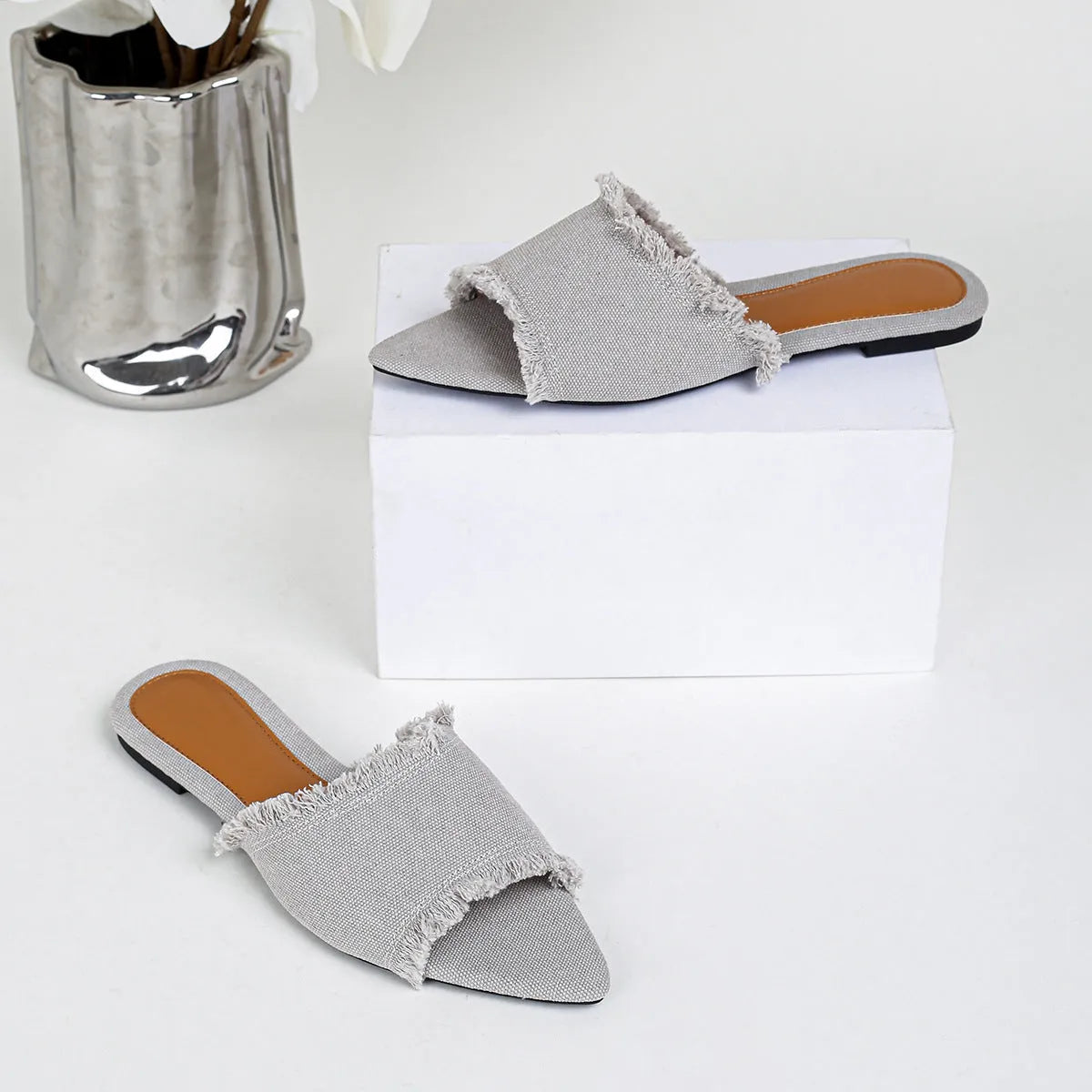 Women's denim flat slippers with tassel detail and leather lining in multiple colours.