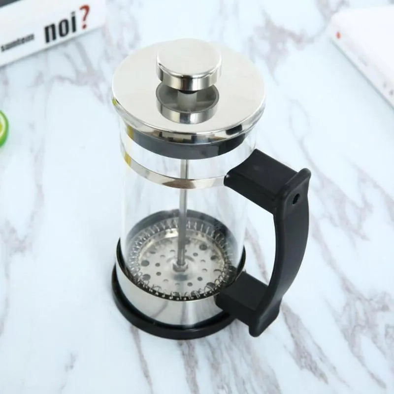 Compact 350ml manual pour-over coffee maker with glass carafe and stainless steel filter.
