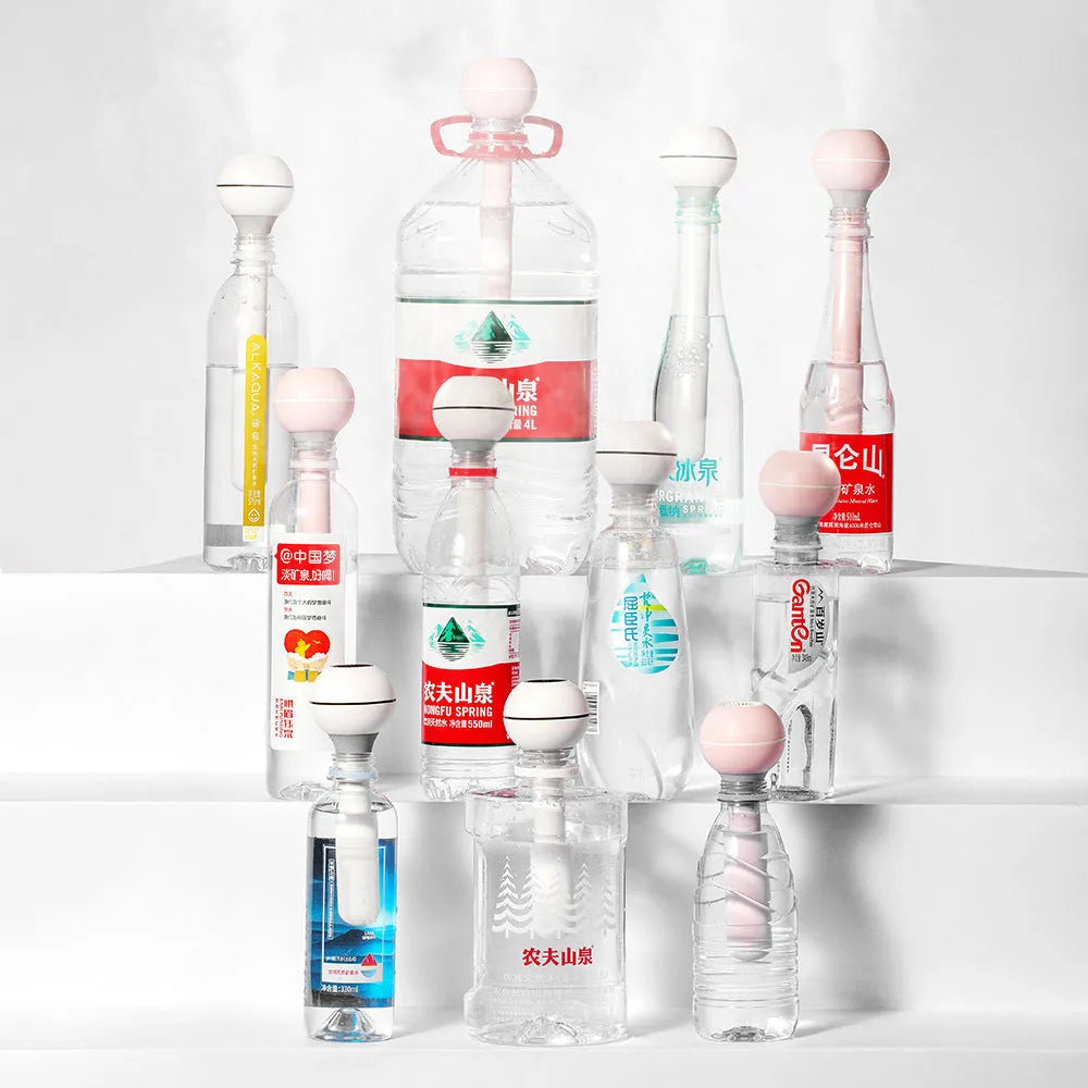 Columnar pink and white Magic Wand personal USB humidifier with water tank on a desk.