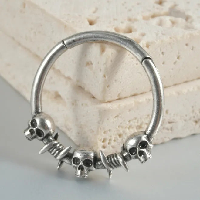 Close-up of copper punk earring with detailed ghost head design in antique silver finish.