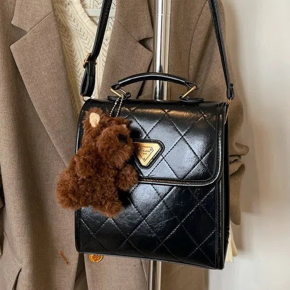 PU mini backpack in brown with stitching detail and pendant, front view
