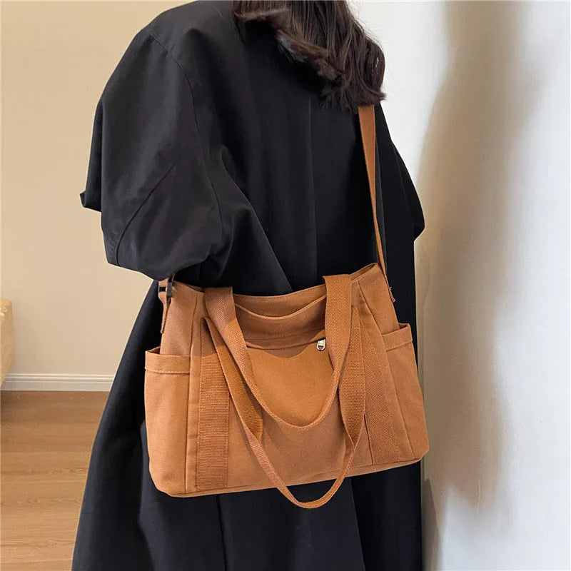 Large polyester canvas shoulder tote bag in solid colour with outer pocket and shoulder strap