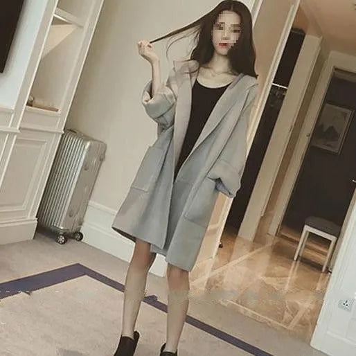 Plus size woman modelling a loose-fit grey cotton coat with lace detail on the sleeves.