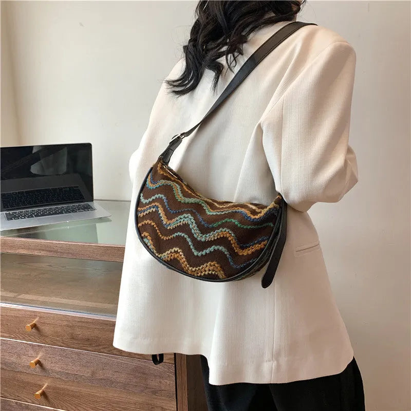 Women's straw woven crossbody bag showing knitted weaving texture and internal phone pocket